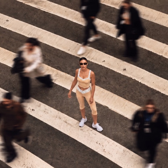 Model in the Florence Active butter gingham set on a city crosswalk, aerial view